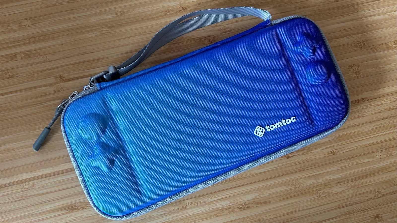 TomToc Nintendo Switch case in blue on a wooden table