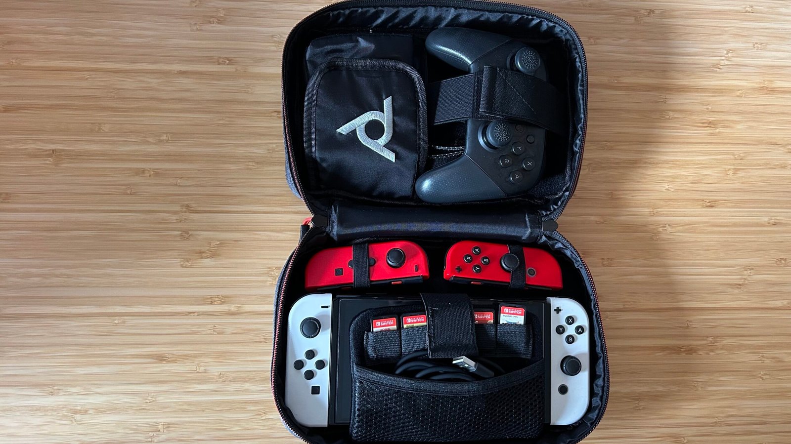 PDP commuter case open with Nintendo Switch, Joy-Con, games, and Pro Controller stored inside