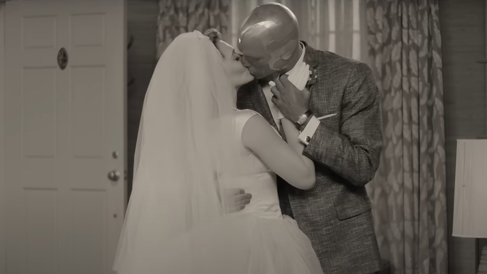 Elizabeth Olsen as Wanda Maximoff and Paul Bettany as Vision kissing while wearing wedding clothes during WandaVision.