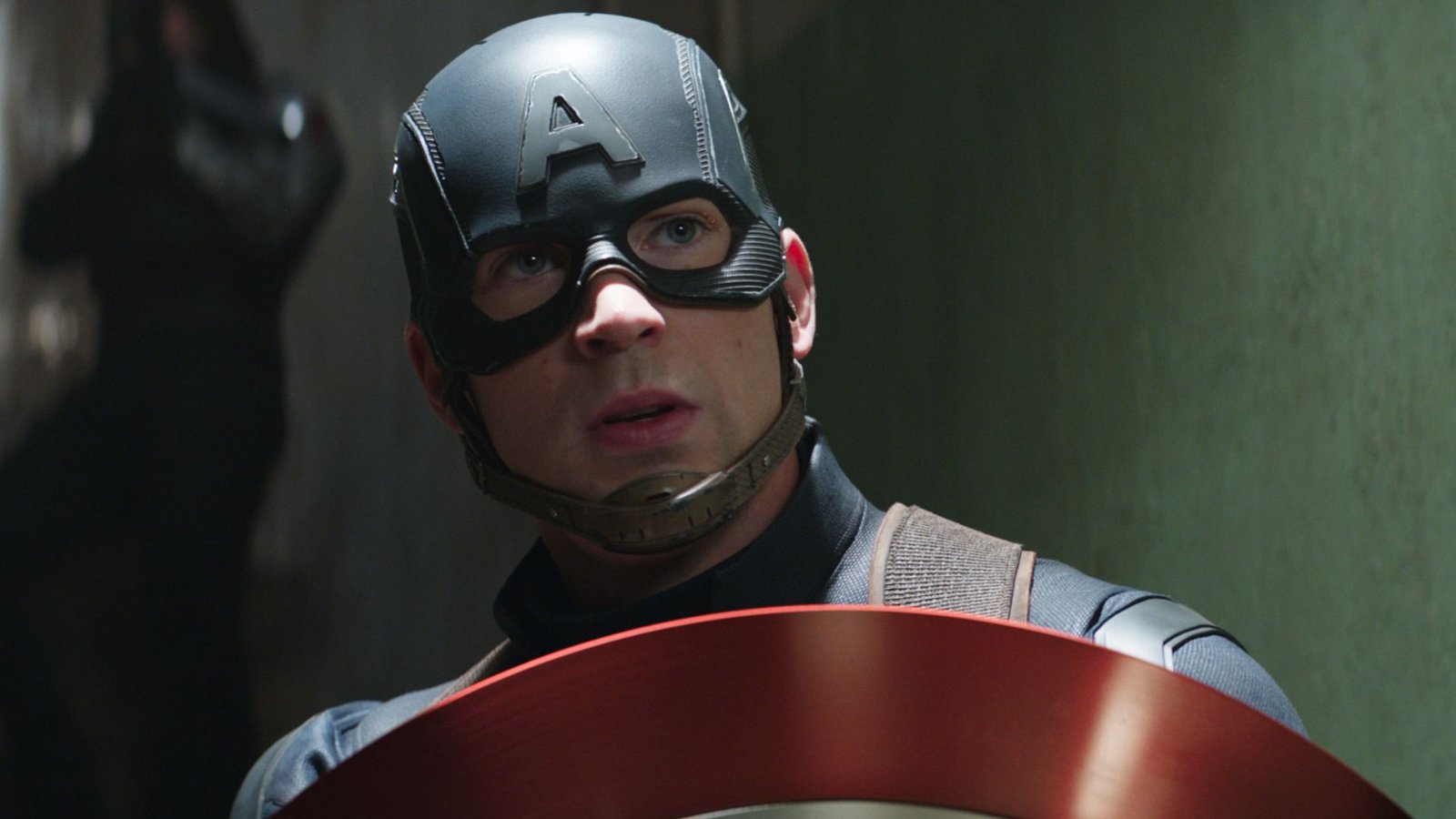 Chris Evans as Steve Rogers AKA Captain America, holding up his iconic vibranium-lined shield.