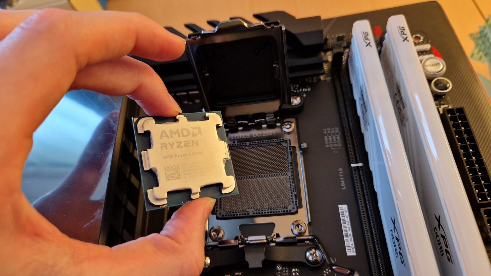 AMD Ryzen 5 8600G being lowered onto a motherboard