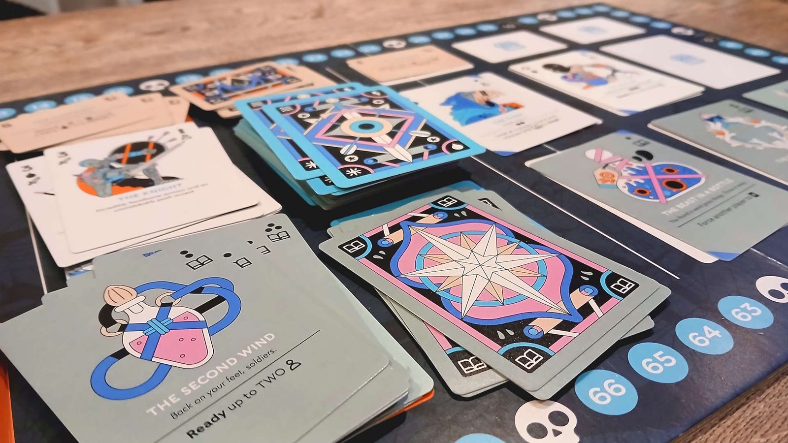 Multiple Fame & Fable cards on the board, which sits on a wooden table
