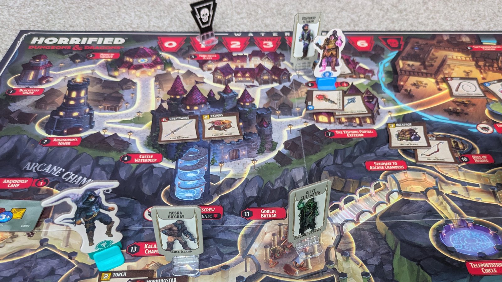 Horrified: Dungeons & Dragons components, tokens, and items laid out on the board, which sits on a gray surface