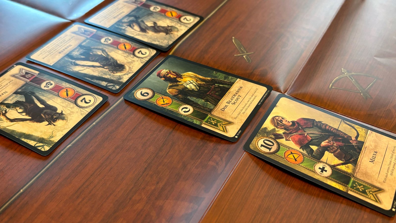 A T-shaped arrangement of Gwent cards on a wood-effect surface