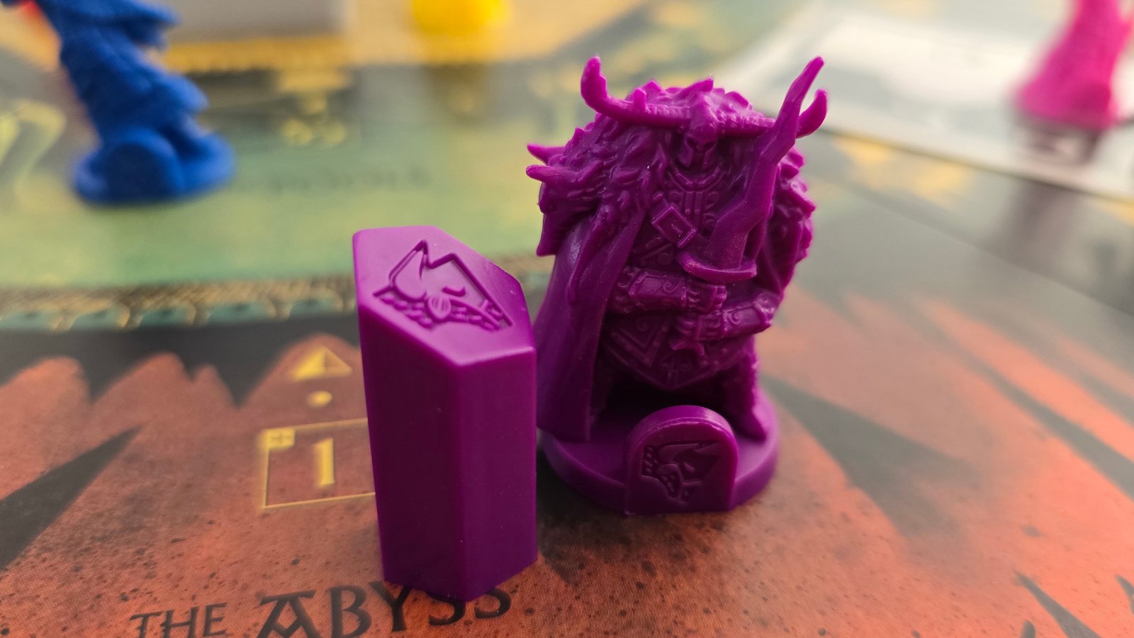 Veiled Fate miniature and token laid out on the board, with more visible in the background