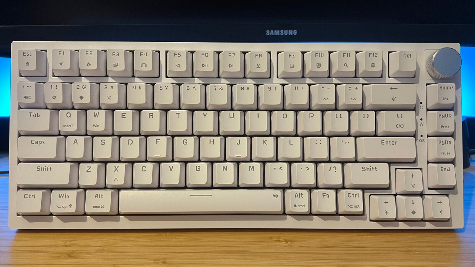 Newmen GM326 gaming keyboard on a wooden desk with blue backlighting