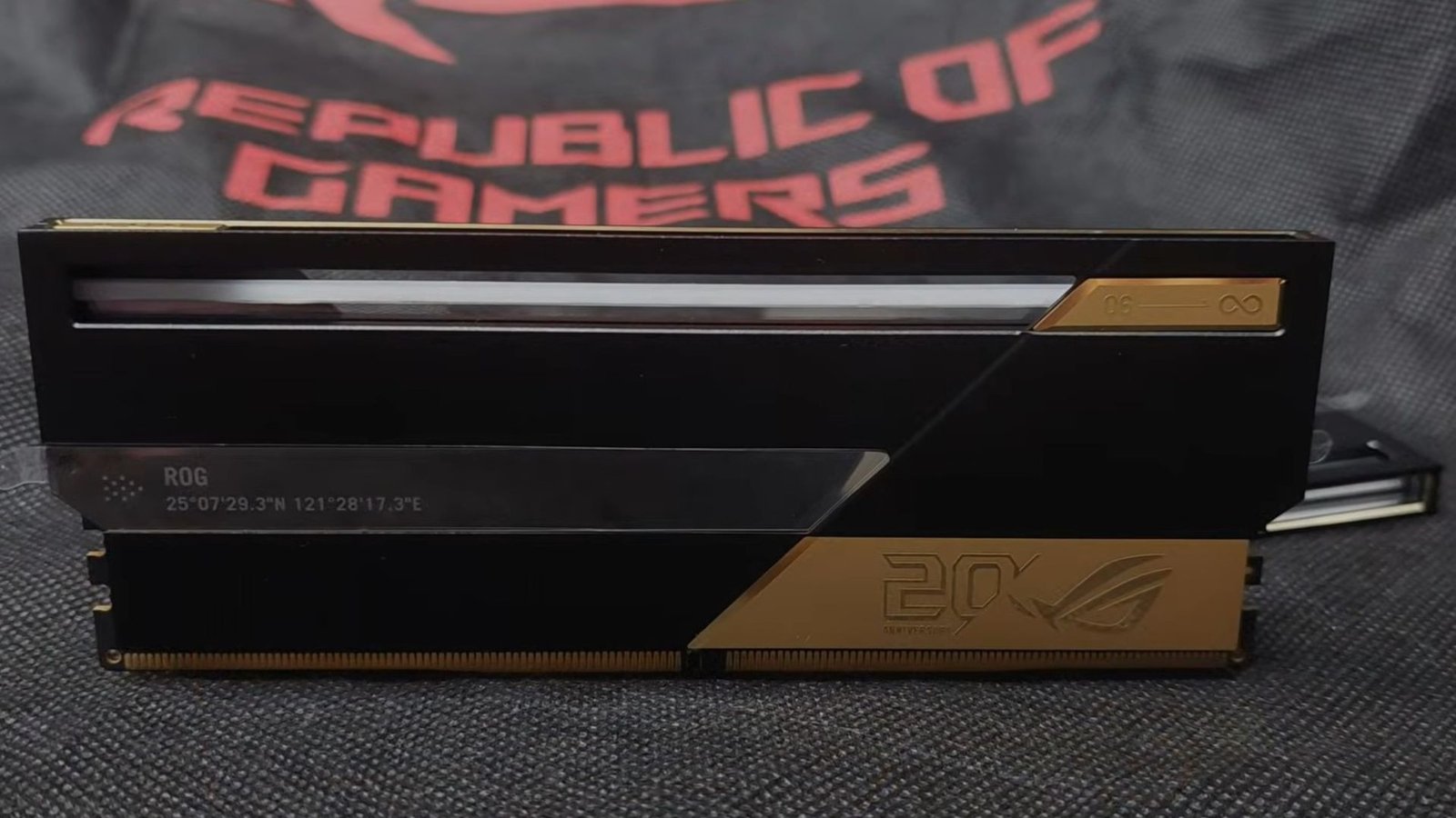 A stick of Asus ROG Edition 20 RAM standing upright in front of a Republic of Gamers cloth bag