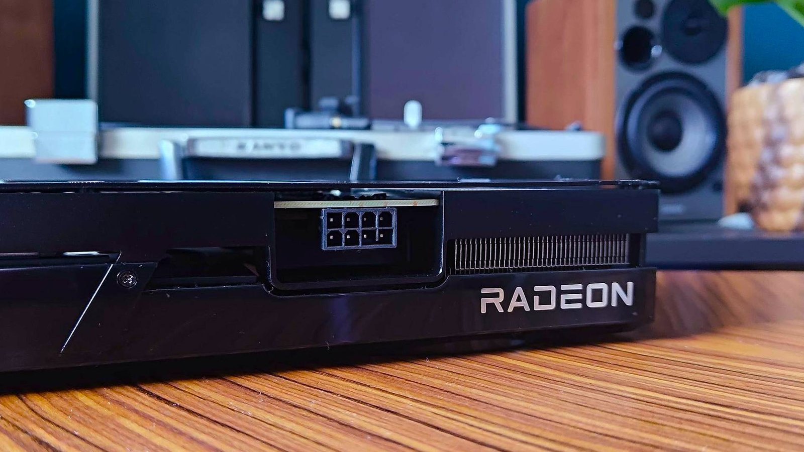 Close up of Radeon logo on AMD GPU sitting on woodgrain table.