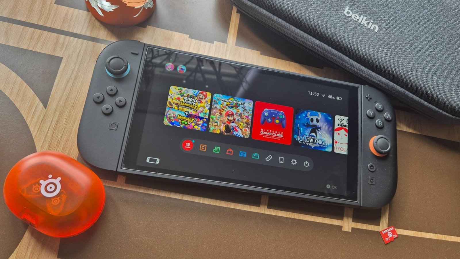 Photo of the Switch 2 sitting on a wooden table with accessories sitting around it.