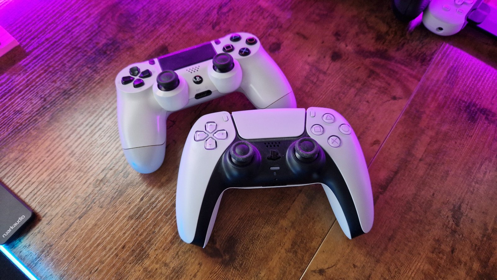 DualShock 4 sat above a DualSense controller on a gaming desk