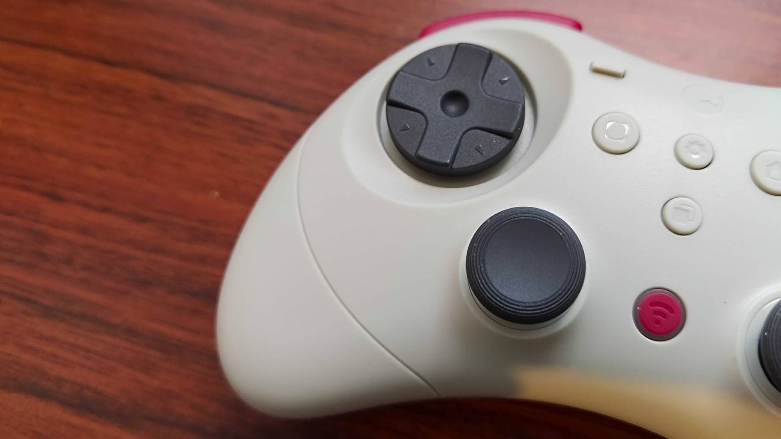Close up of Gulikit Elves 2 Pro D-pad on woodgrain desk.