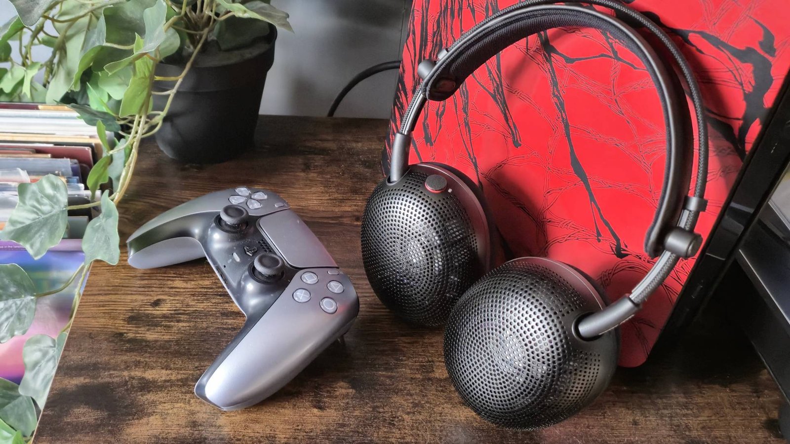 Photo of the Sony Inzone H6 Air headset sitting next to a silver PS5 DualSense controller.