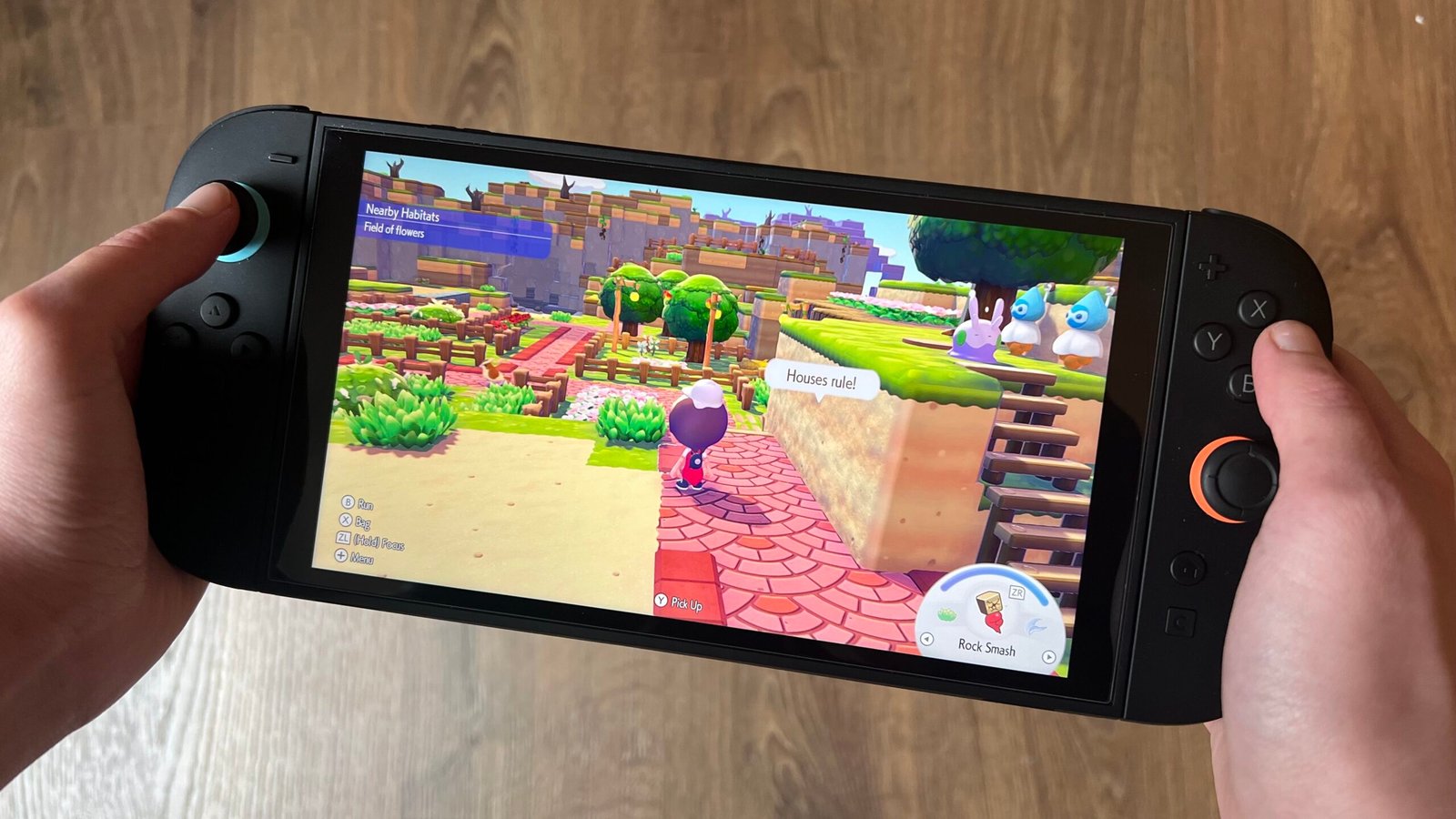 Hands holding Nintendo Switch 2 with Pokemon Pokopia running on screen